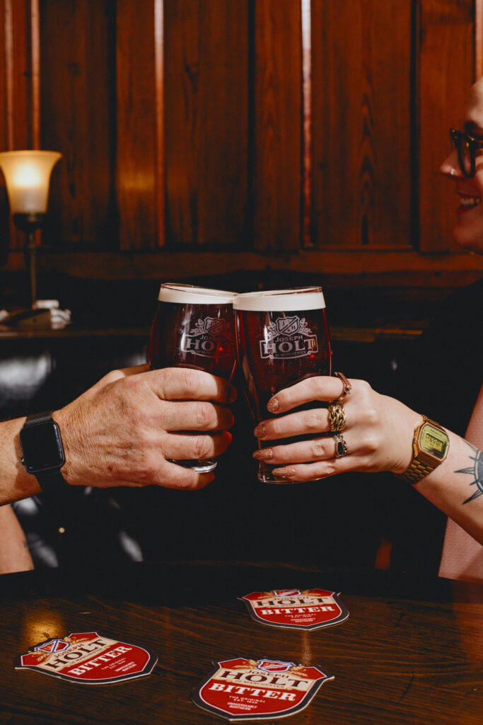 Two people having a cheers with pints of Bitter.