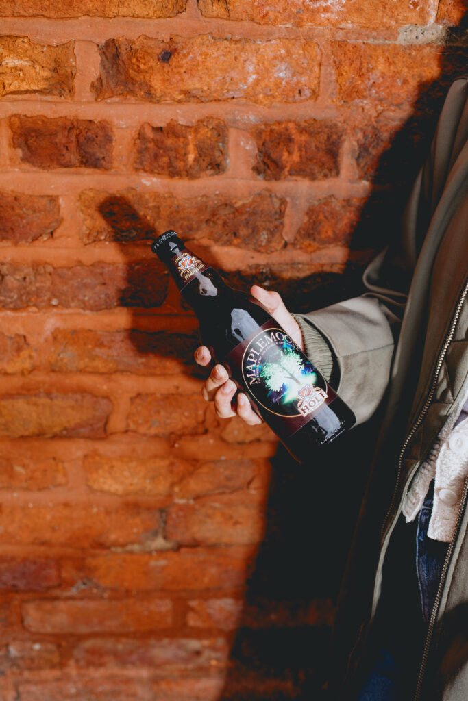 A woman holding a bottle of Maple Moon.