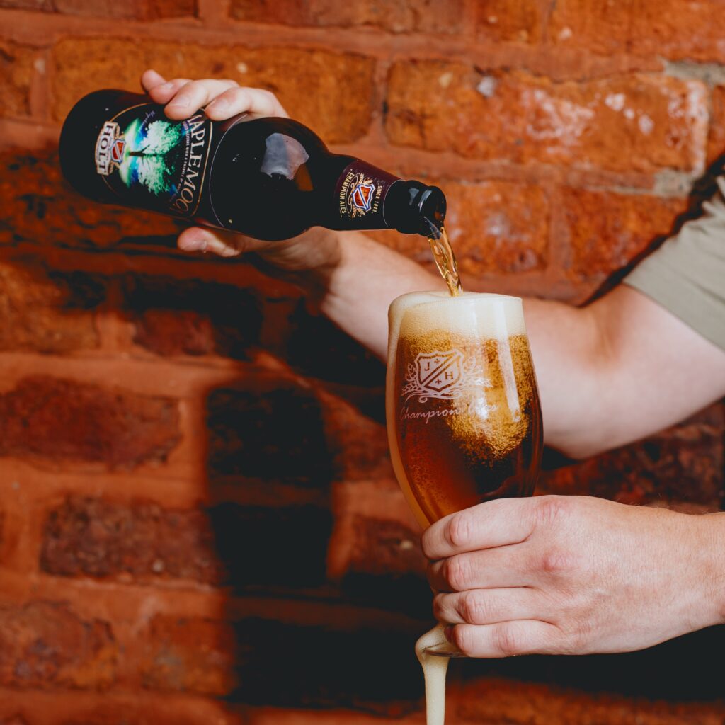 Maple Moon bottle pouring beer into a glass.