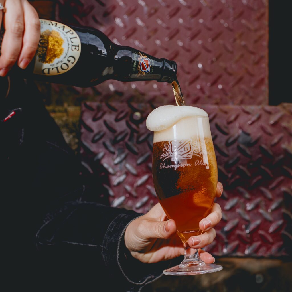 Maple Gold bottle pouring beer into a glass.