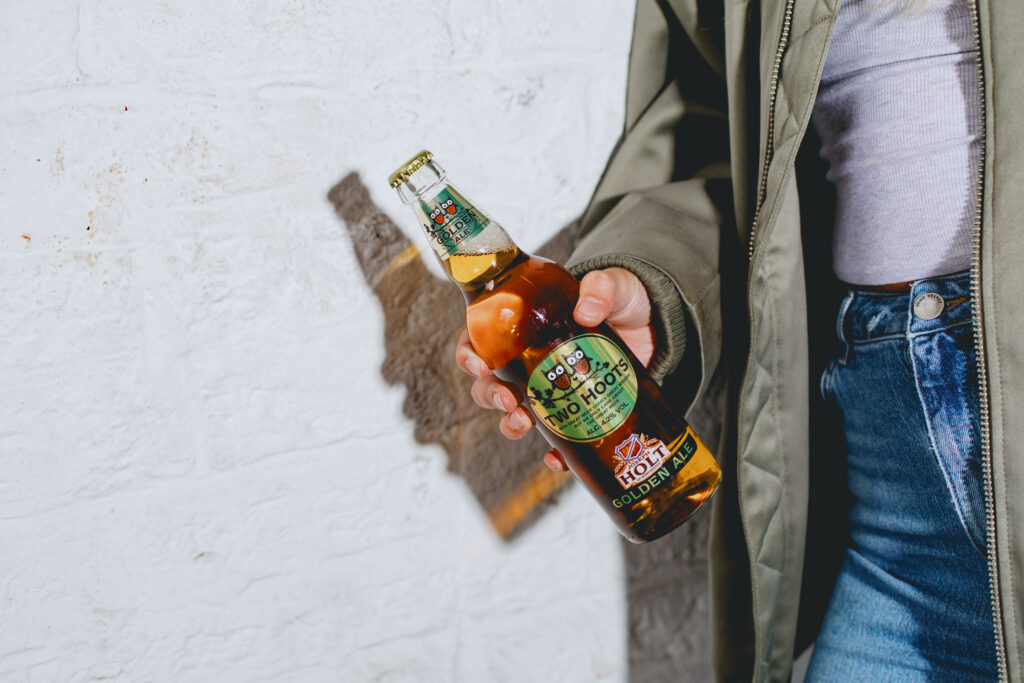 A woman holding a Two Hoots bottle.