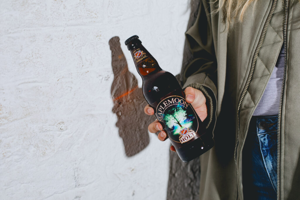 A woman holding a Maple Moon bottle.