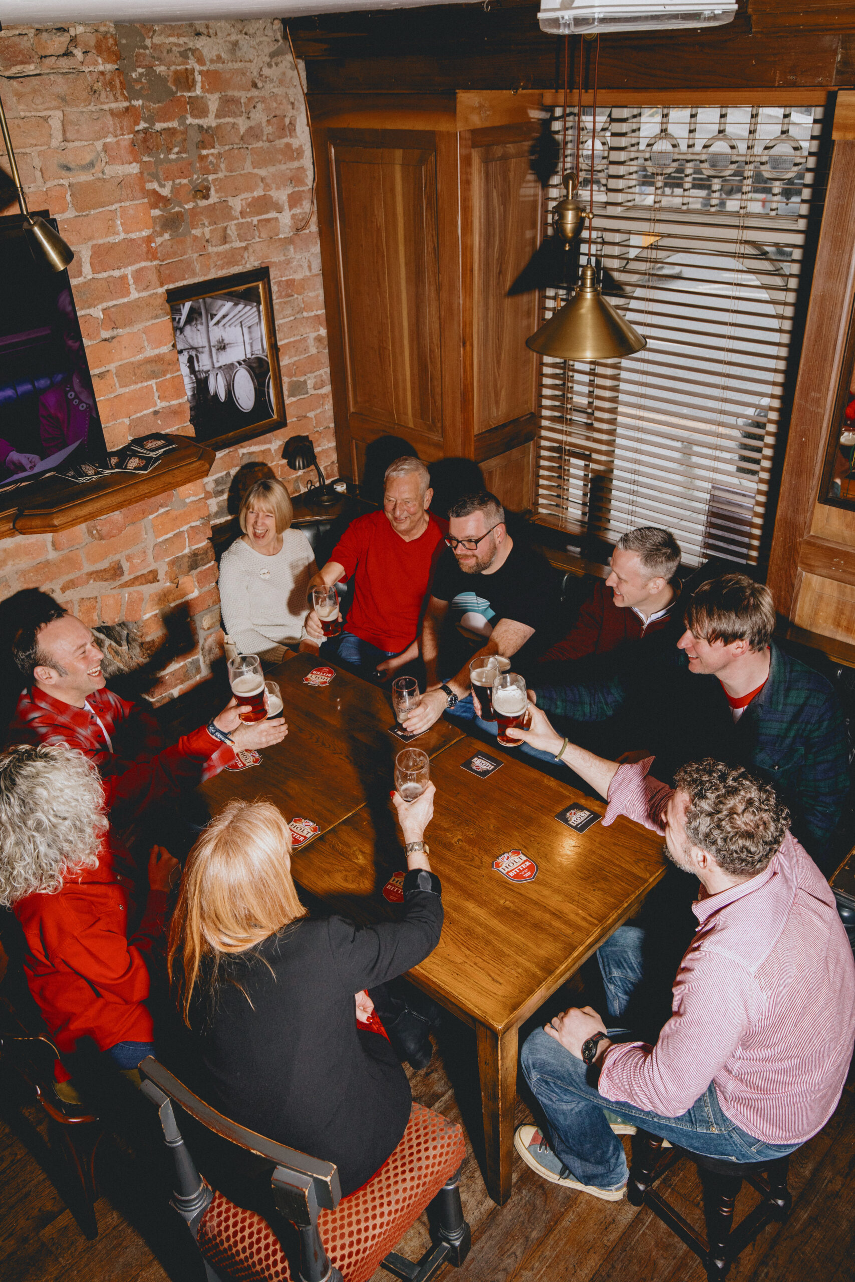 Customers sat round a table in a pub drinking Bitter