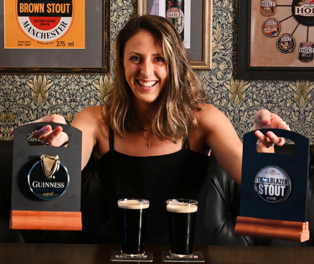 A woman in front of 2 pints of stout