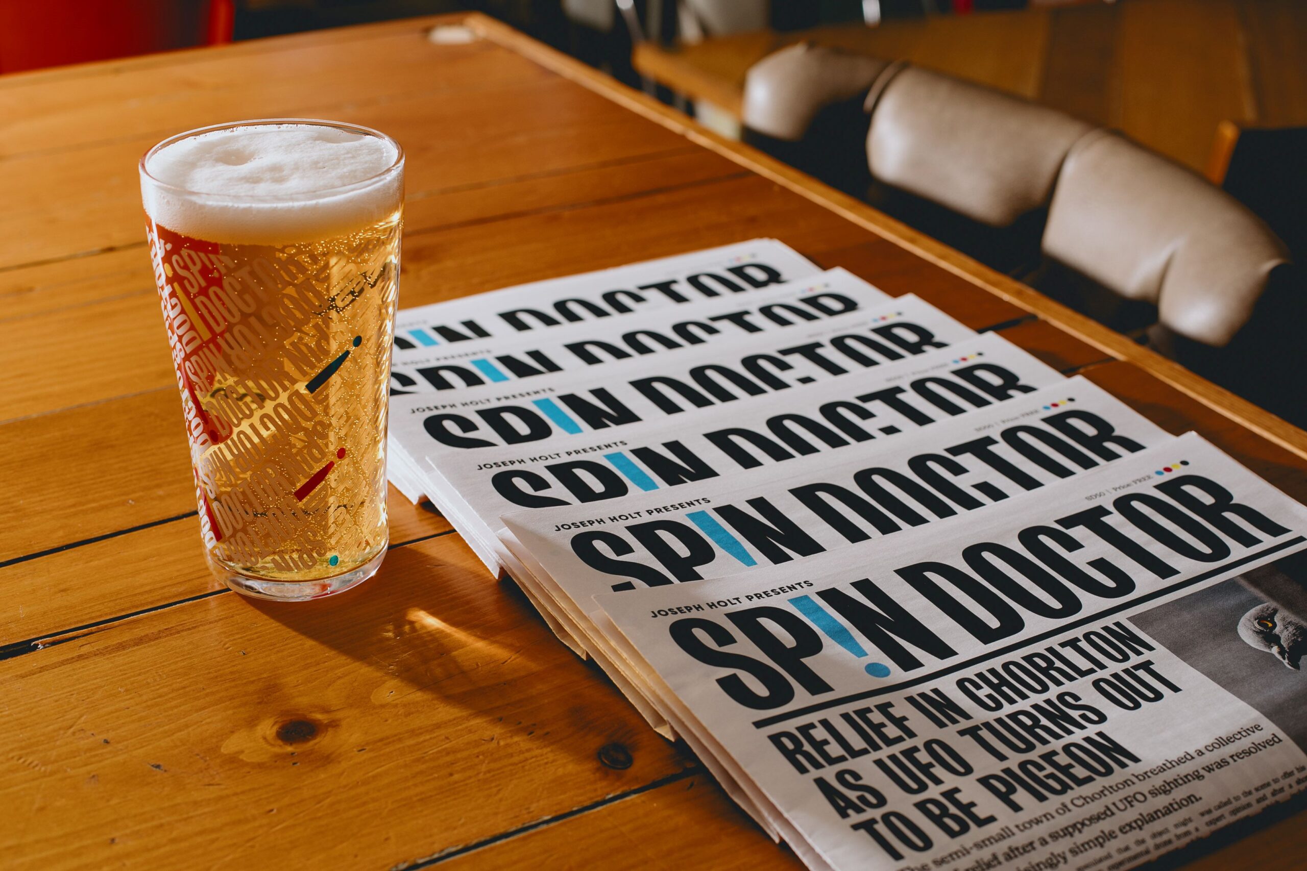 Pint of beer next to newspapers