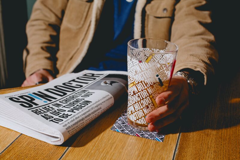 A newspaper and a pint on a table