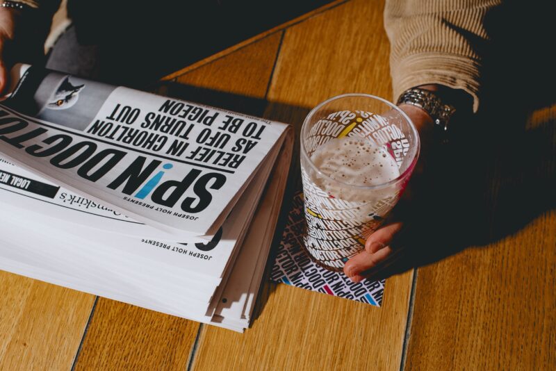 Folded newspapers next to a pint